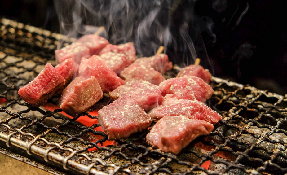 An image of beef fillets cooking on a grill. 